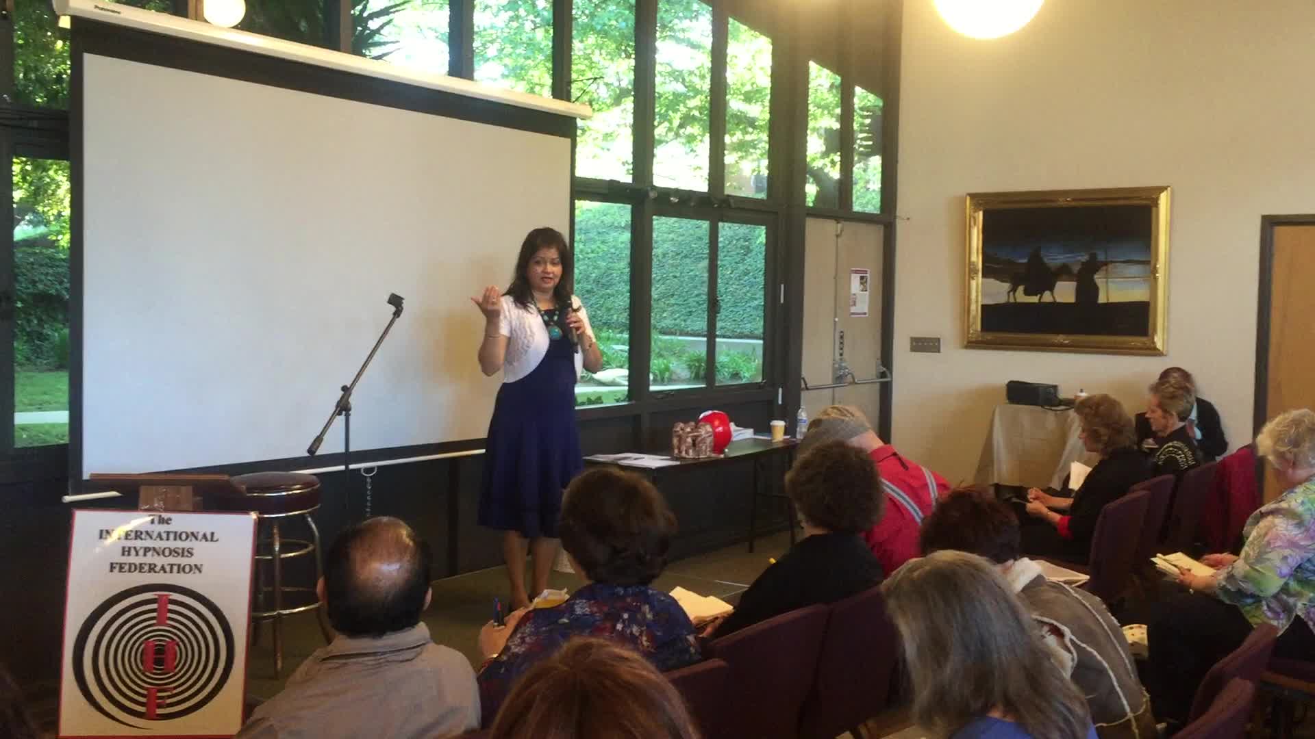 Hena presenting to an audience during a workshop or conference